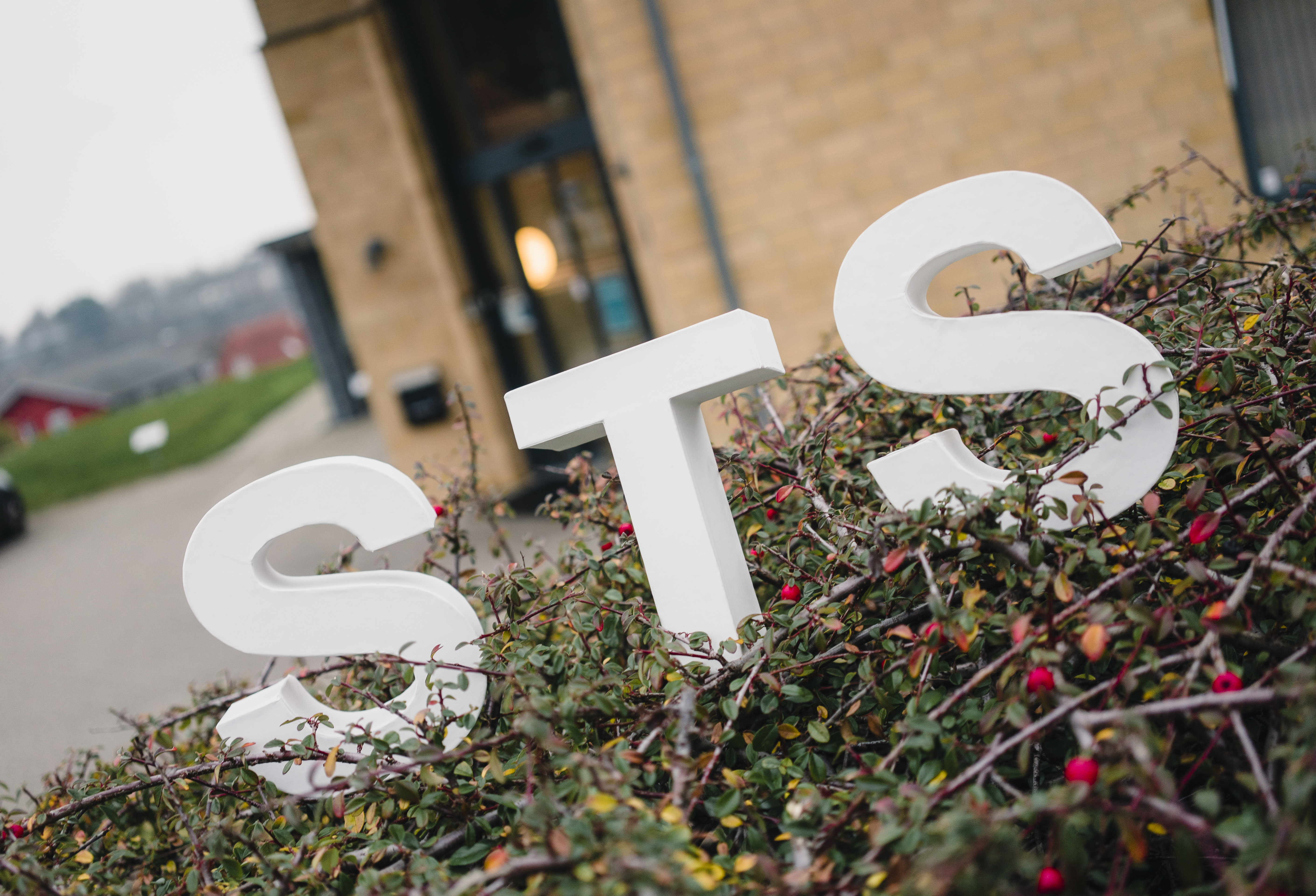 STS-bogstaver i busk foran Socialtilsyn Syds bygning